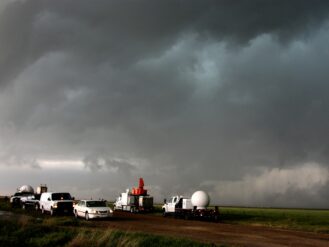 A fleet of VORTEX2 vehicles tracks a supercell thunderstorm near Dumas. The blue-green color in the cloud is associated with large hail.